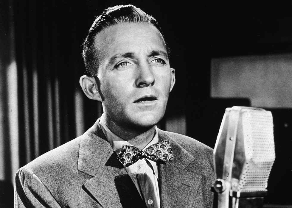 Bing Crosby sings into a microphone.