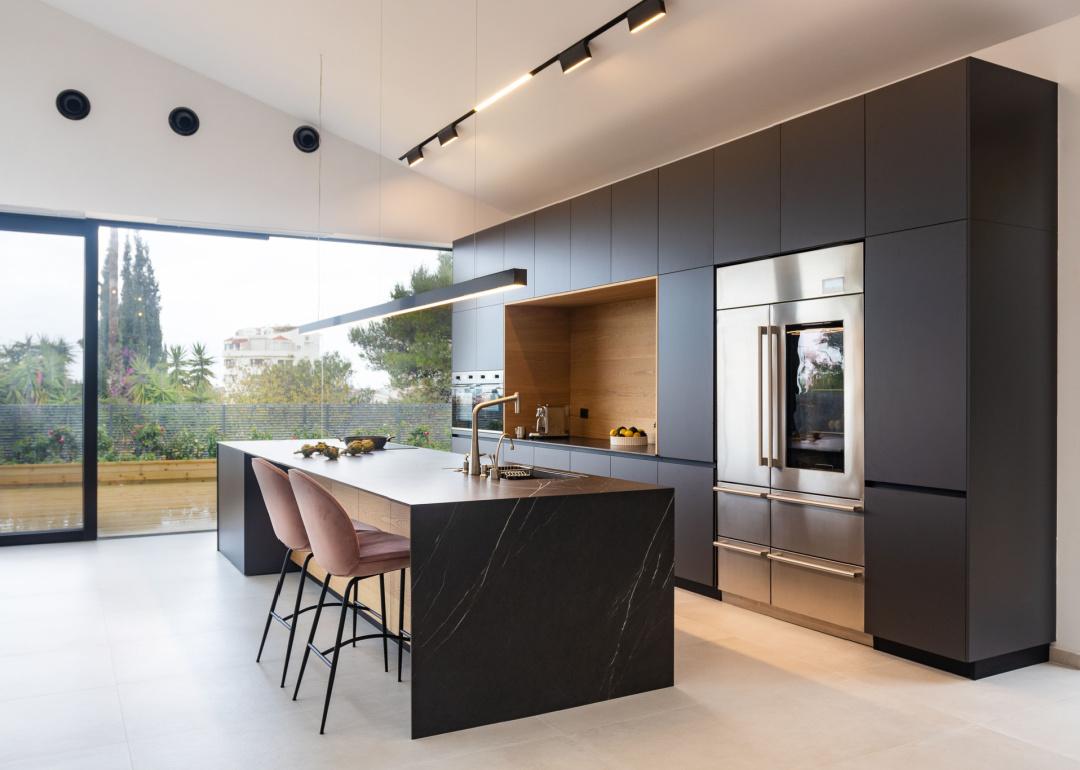 Modern kitchen with black cabinets and island.