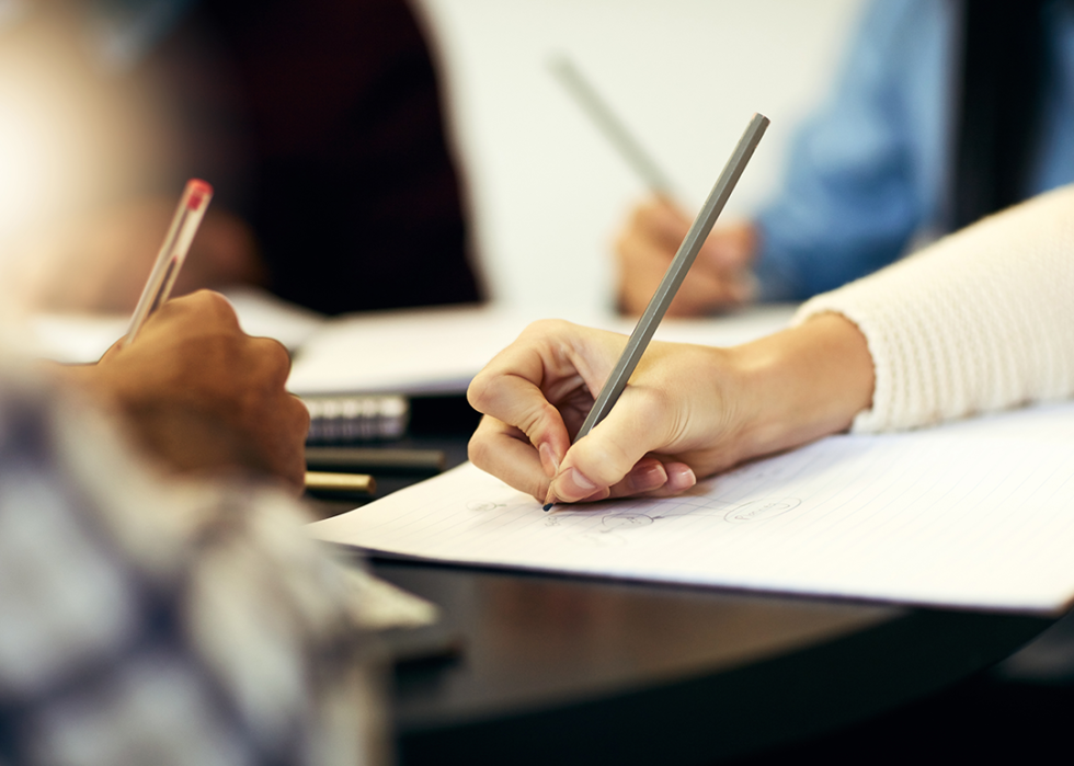 Cropped view of hand writing in notebook.