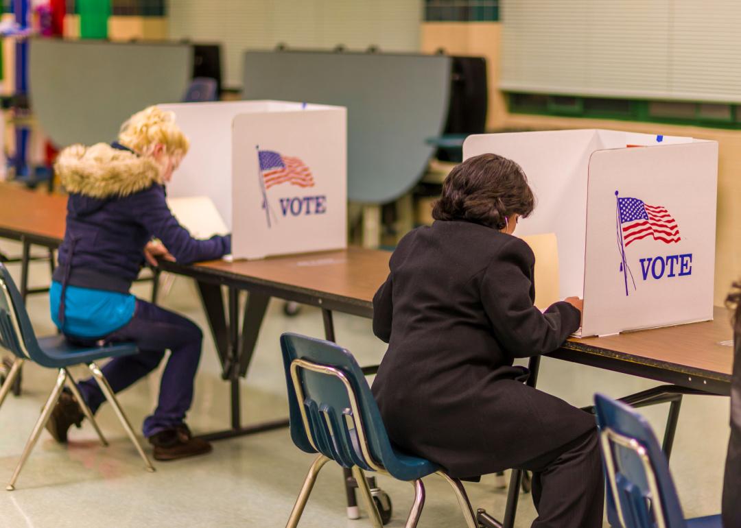 People fill out ballots in voting booth