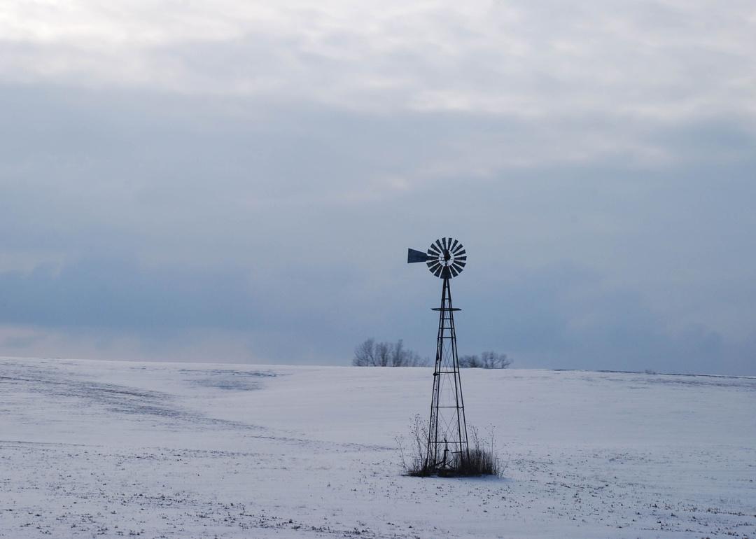 A windmill in a snowy winter landscape.