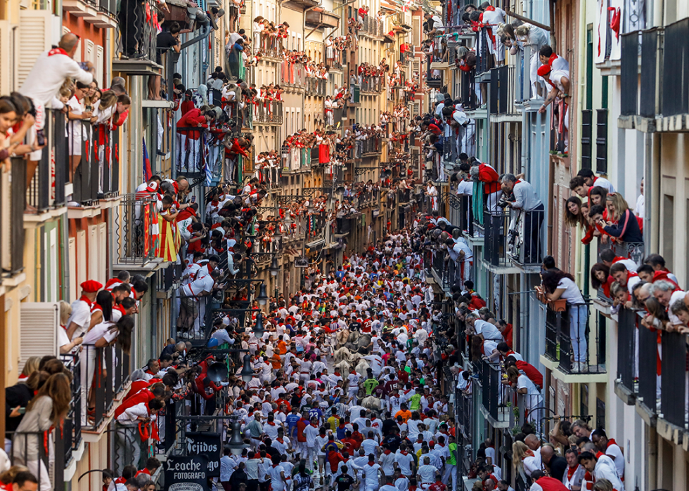 Crowds fill the streets, watching the San Fermin Festival in Pamplona.