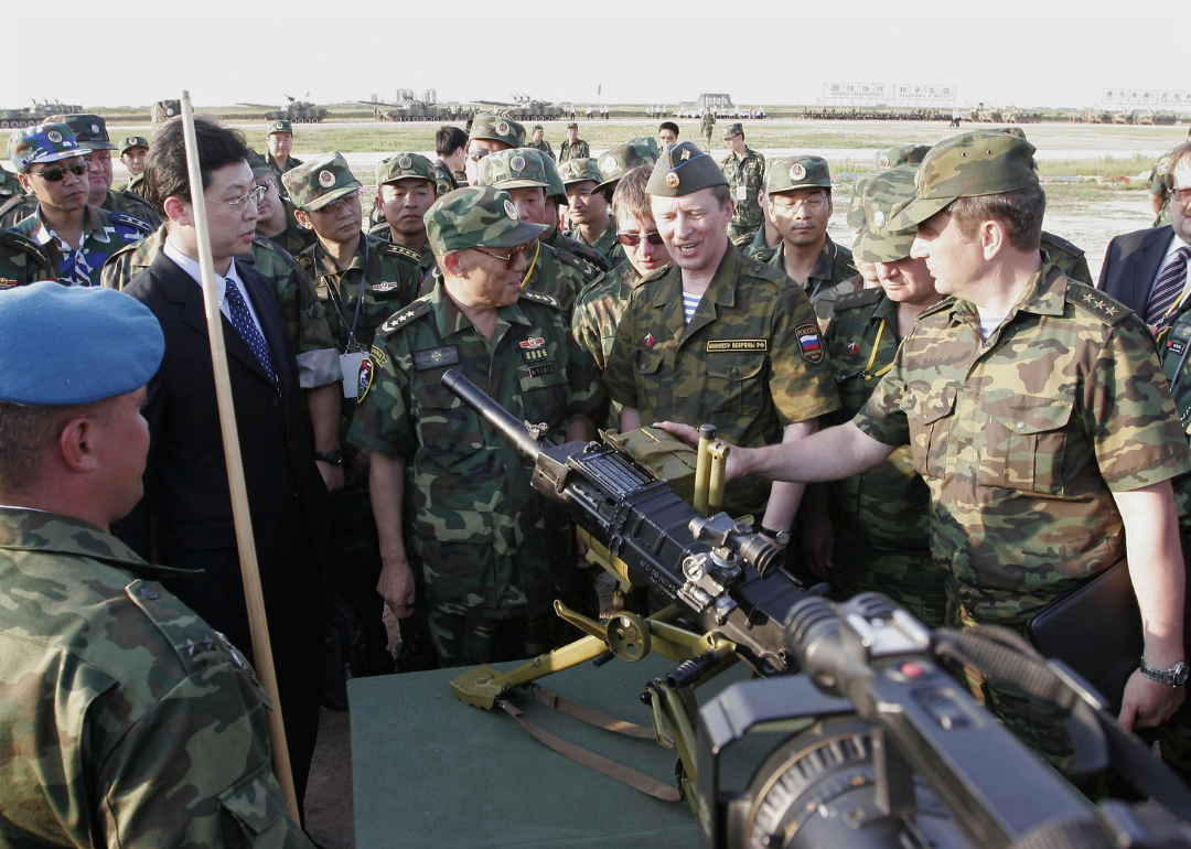 Chinese and Russian officials review machine-gun during military exercises