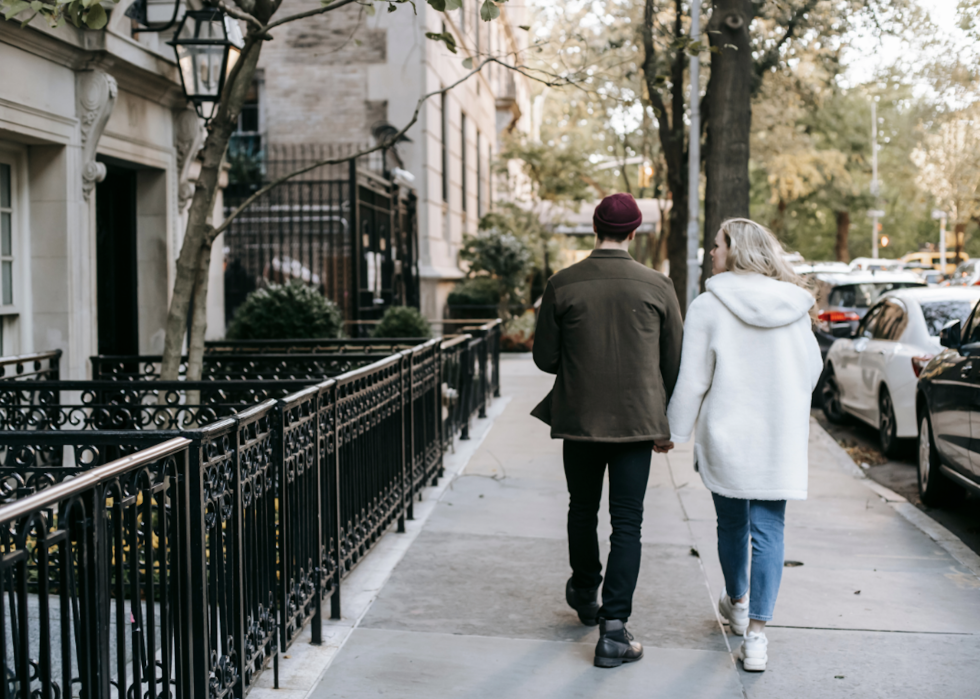A young couple walks along a sidewalk