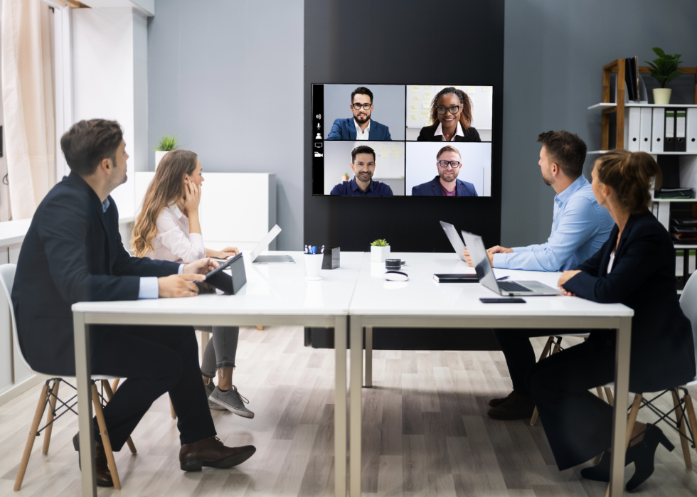 Office meeting featuring in person and virtual attendees