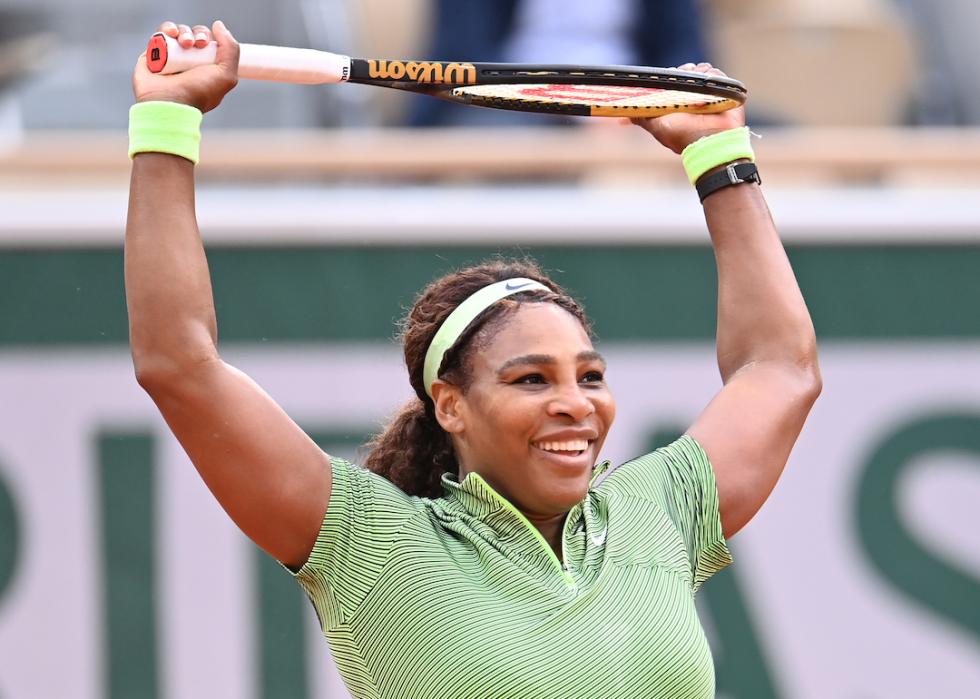 Serena Williams holds a tennis racquet over her head at the 2021 French Open Tennis Tournament.