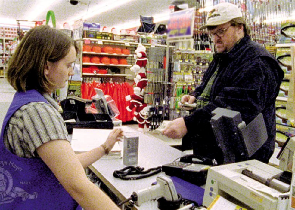 Michael Moore interacts with a cashier at a store