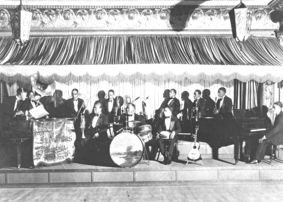 Louis Armstrong and his orchestra appear onstage at the Sunset Cafe nightclub.