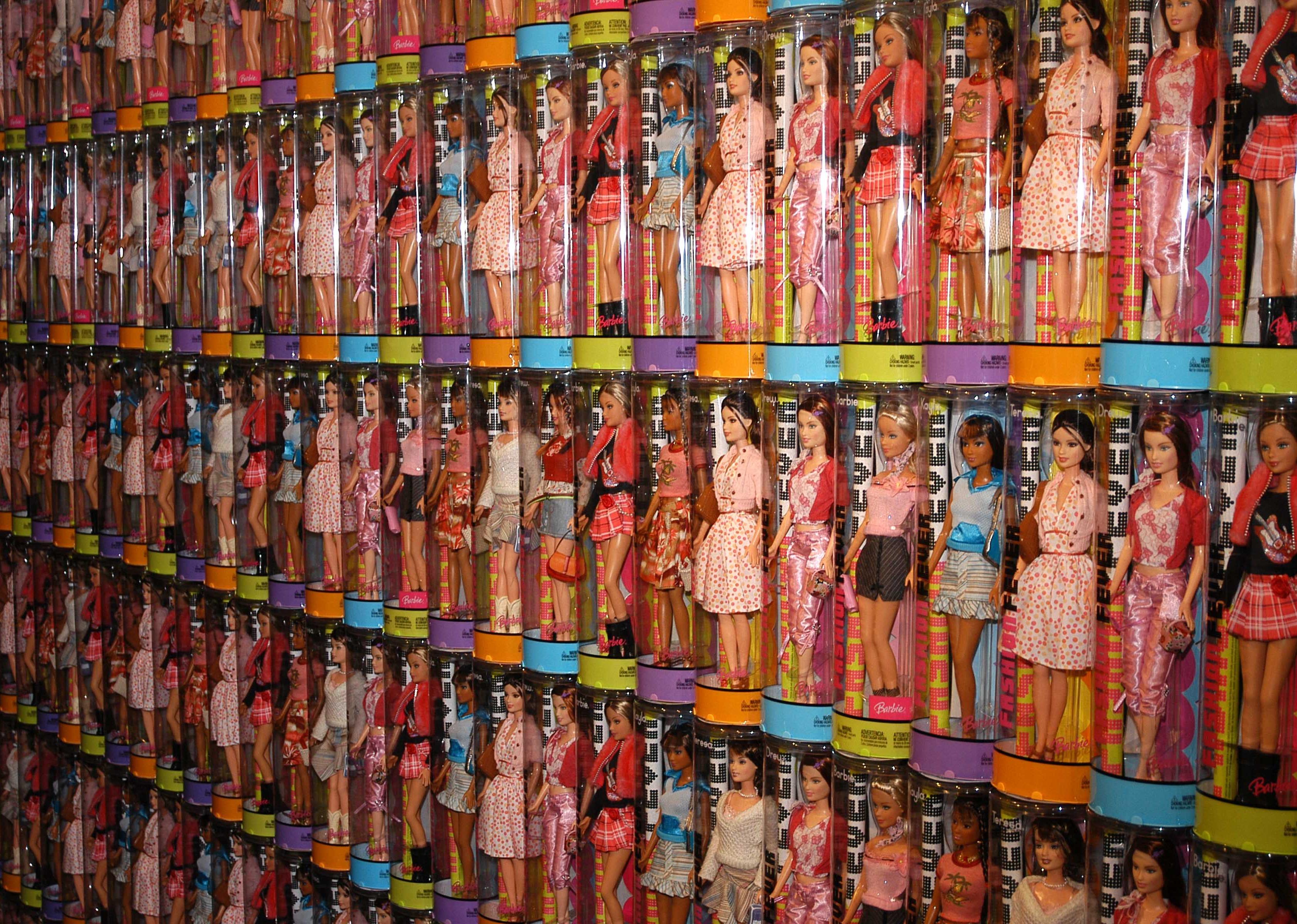 Rows of shelves lined with clear cylinders of Barbie dolls.
