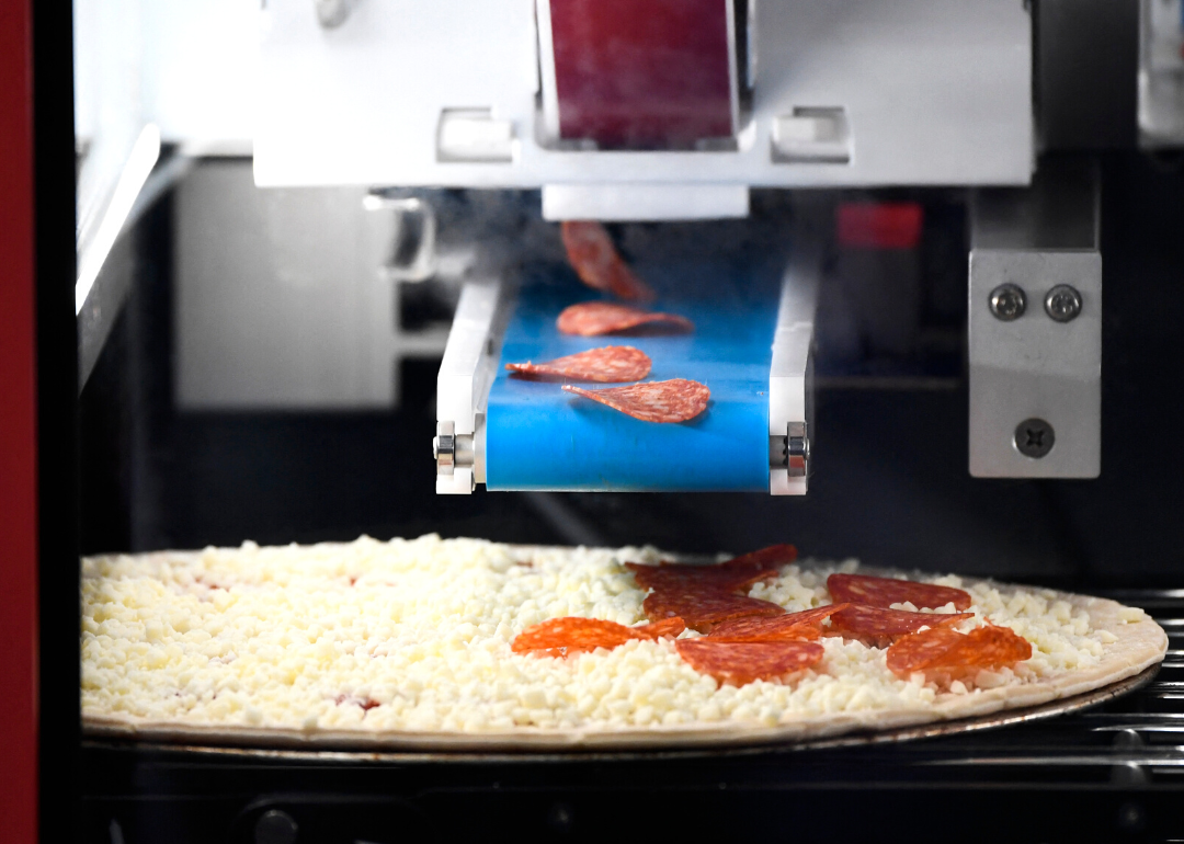 The Picnic automated pizza assembly system making pizzas.