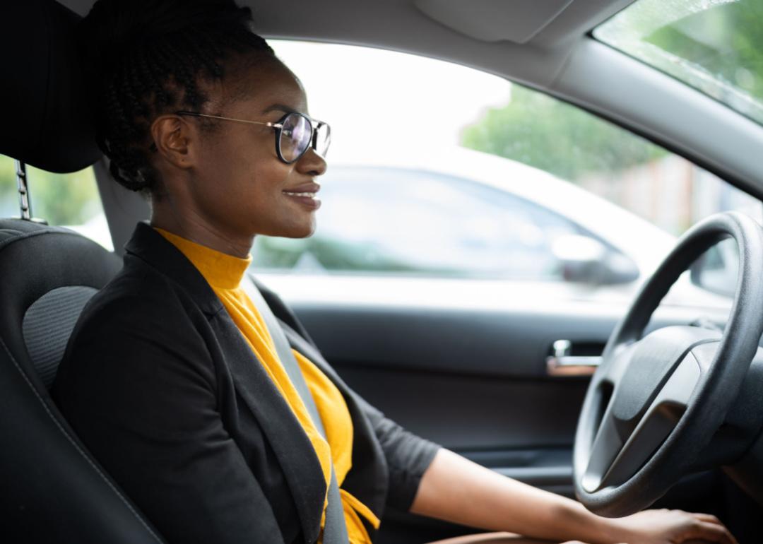 A woman in a car driving on autopilot.