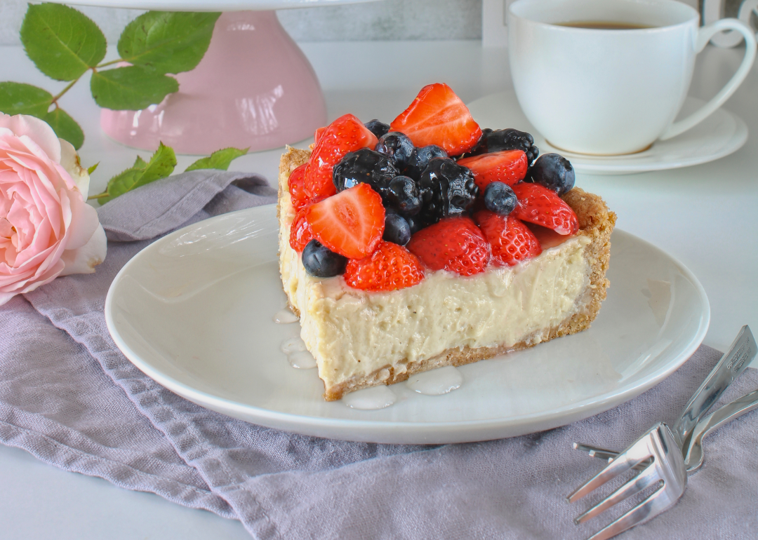 A simple piece of white cheesecake with berries.