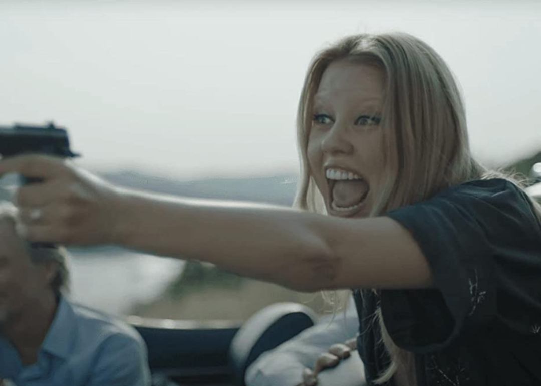 Mia Goth points a gun offscreen in a scene from "Infinity Pool"