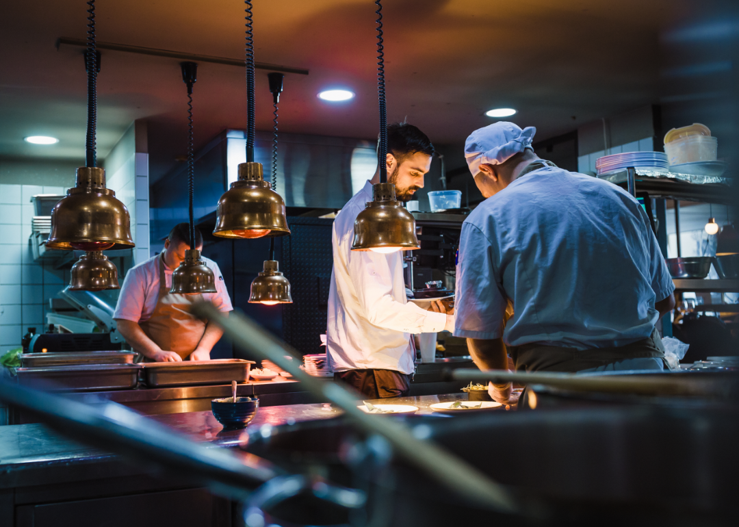 Kitchen staff work together in a clean, modern restaurant.