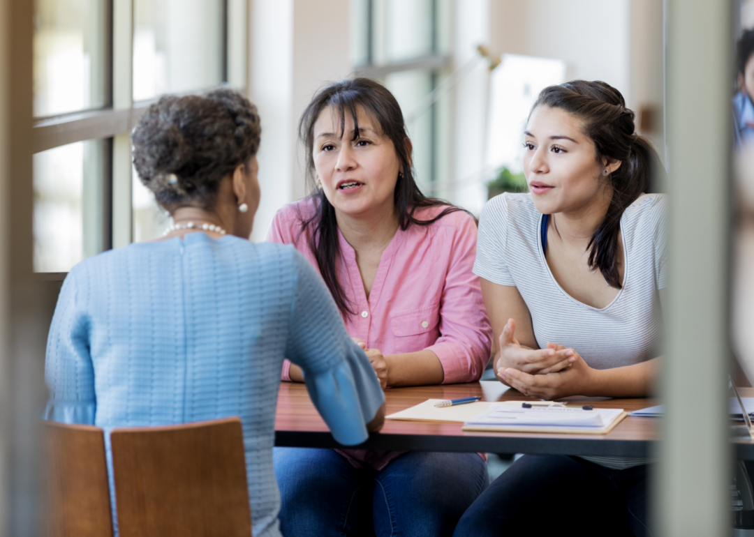 A mother and daughter consult with a loan officer.