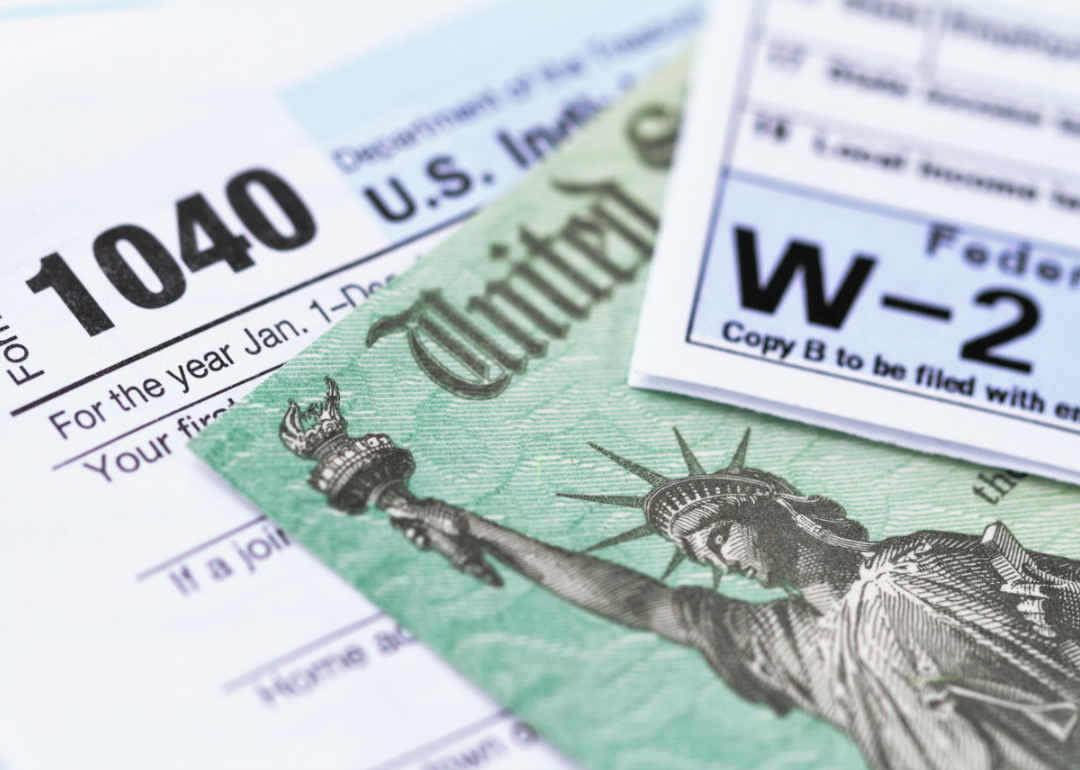 Tax forms and a tax refund check lie in a pile of documents.