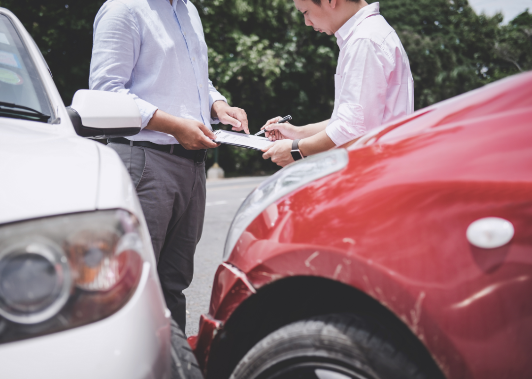 An insurance agent getting a signature for a damaged car.