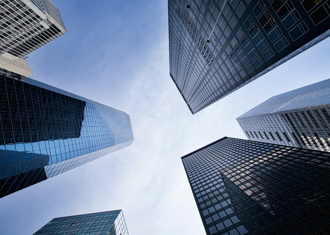 An upward view of corporate office buildings against a blue sky.