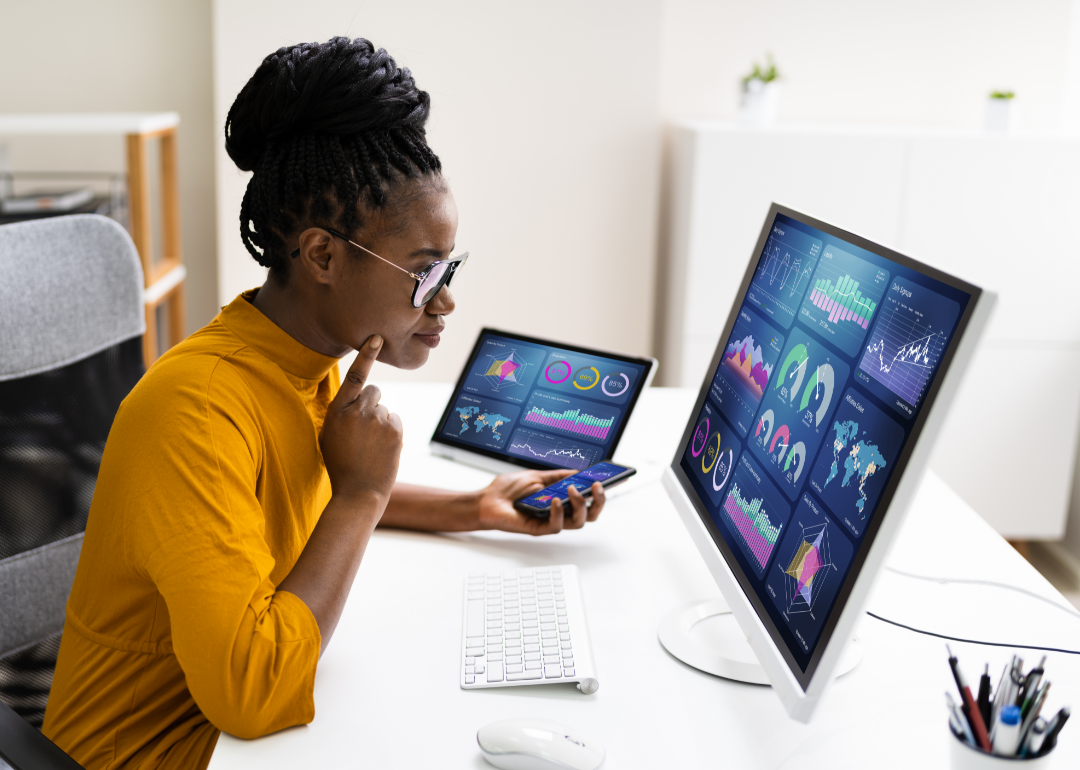 A woman seated at a desk analyzing business data.