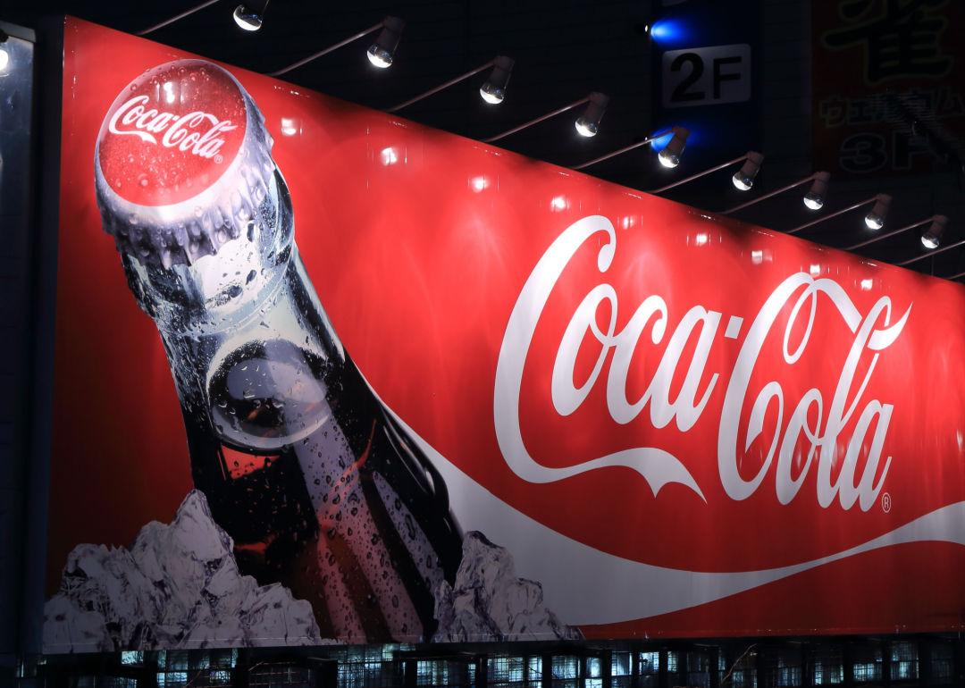 A Coca Cola billboard illuminated at night.