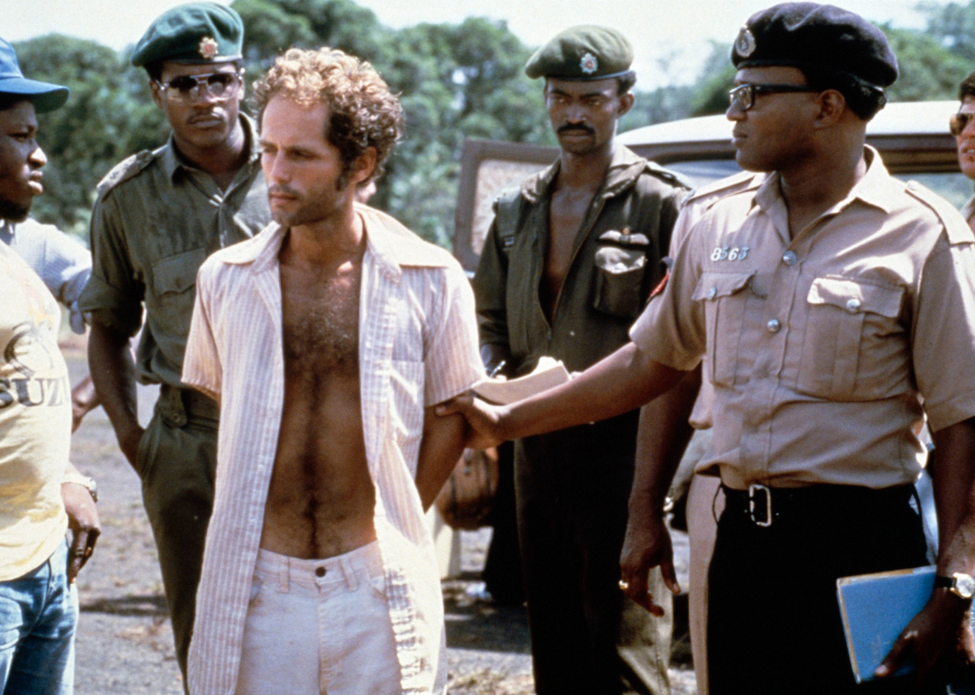 People's Temple follower Larry Layton stands with police following his arrest in Jonestown.