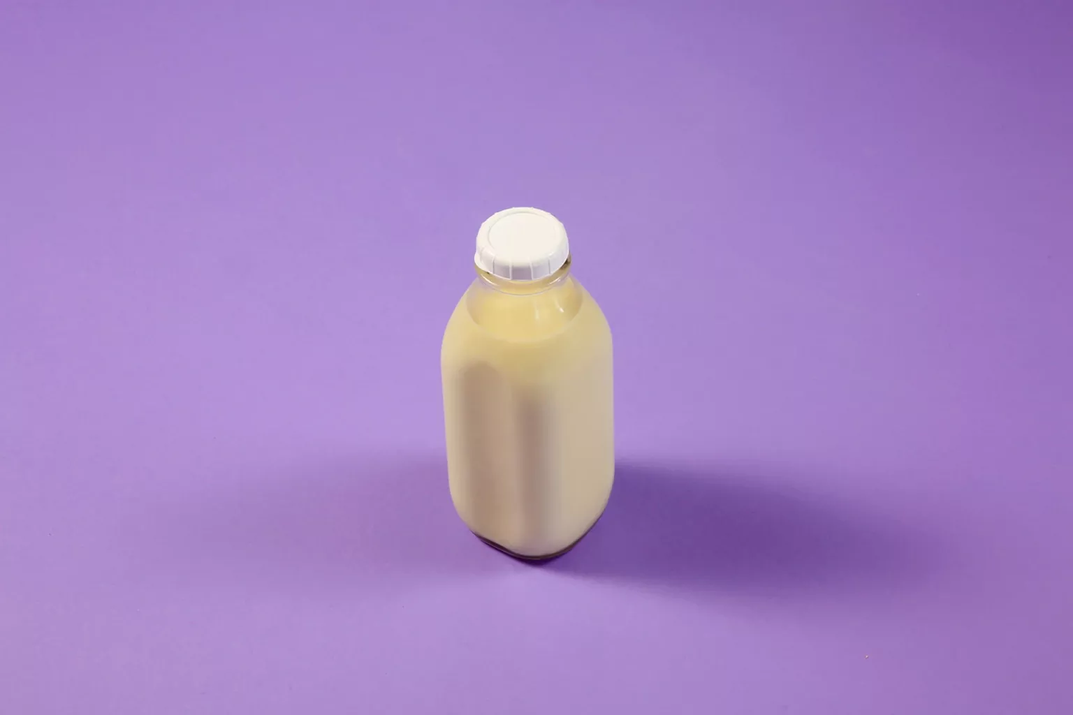 Milk fills a reusable glass bottle