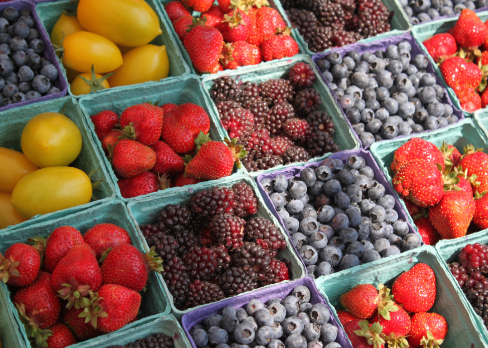 Cartons of various types of berries at a farmers market