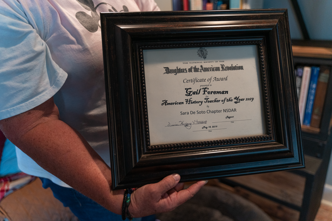 A person holds a framed certificate.