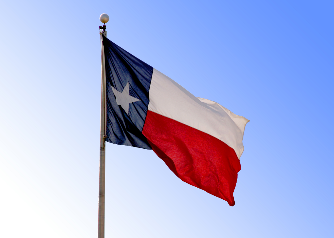 Texas state flag waving against a clear blue sky.