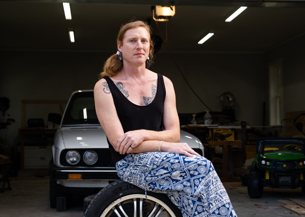 Anna Ray sits in front of her garage and her 1988 BMW E28 535i.