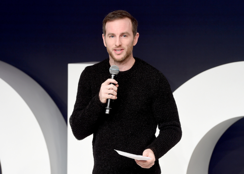 Joe Gebbia speaks on stage at a corporate event.
