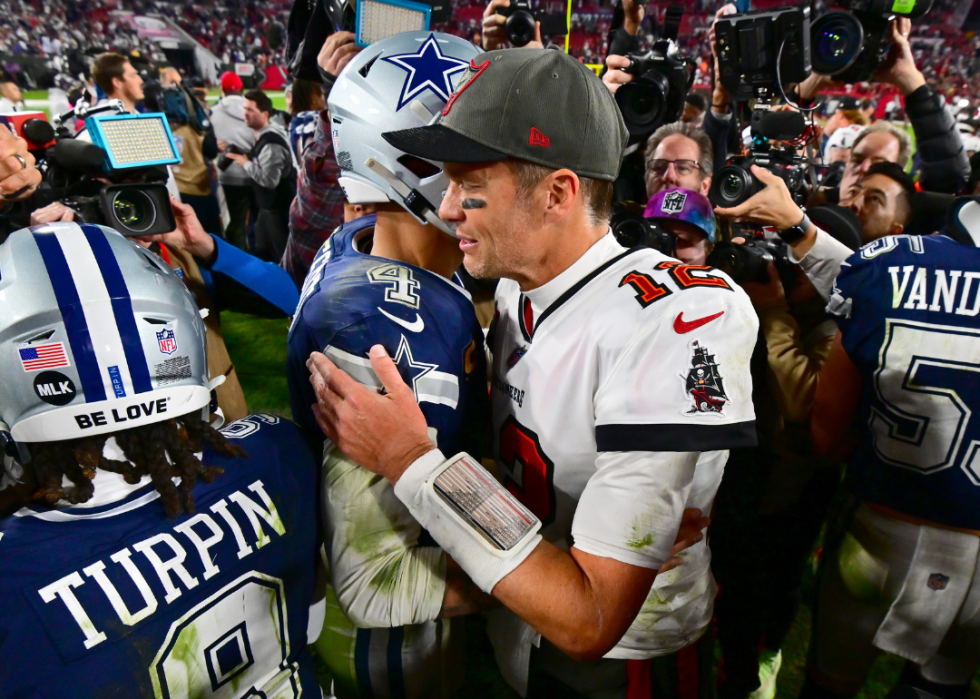 Dak Prescott #4 of the Dallas Cowboys and Tom Brady #12 of the Tampa Bay Buccaneers embrace on the field after their game in the NFC Wild Card playoff game at Raymond James Stadium on January 16, 2023 in Tampa, Florida. 