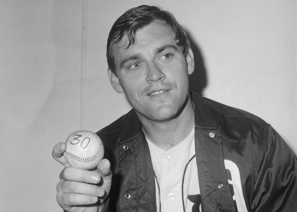 Detroit Tigers' Denny McLain in dressing room holding 30-win ball after the Detroit-Athletics game.