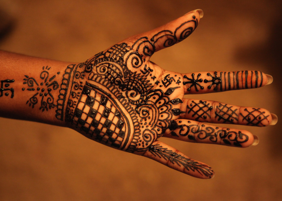A close up of a person's hand covered in recently applied henna. 