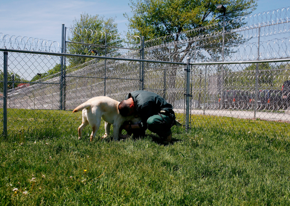A prisoner at the mid-Orange Correctional facility in Warwick, New York hugs a puppy he is training.