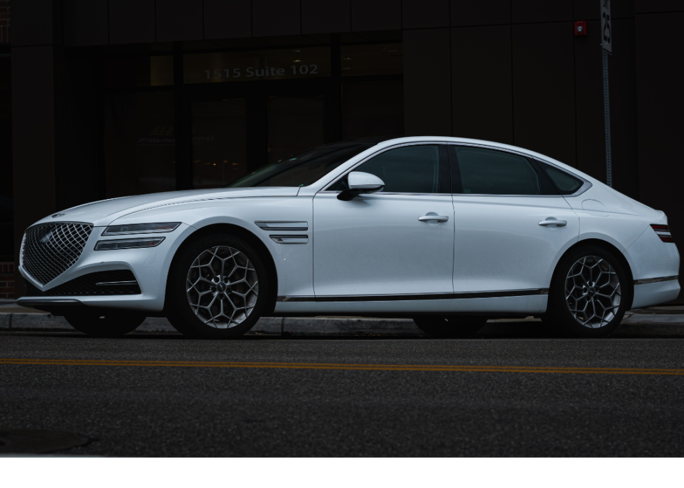 A closeup of a white 2021 Genesis G80 with a dark background