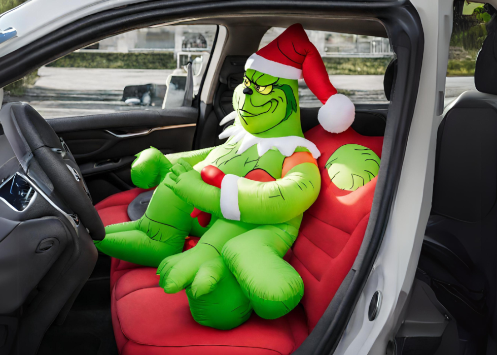 An infaltable Grinch in the front seat of a car