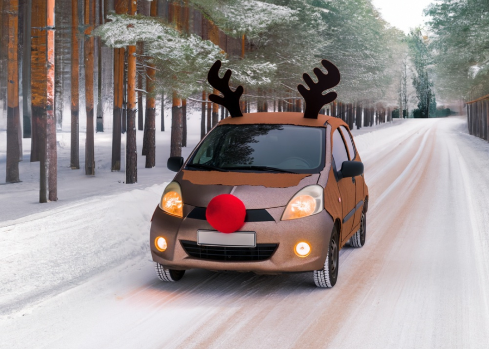A car driving on a winter road with a reindeer car kit on it