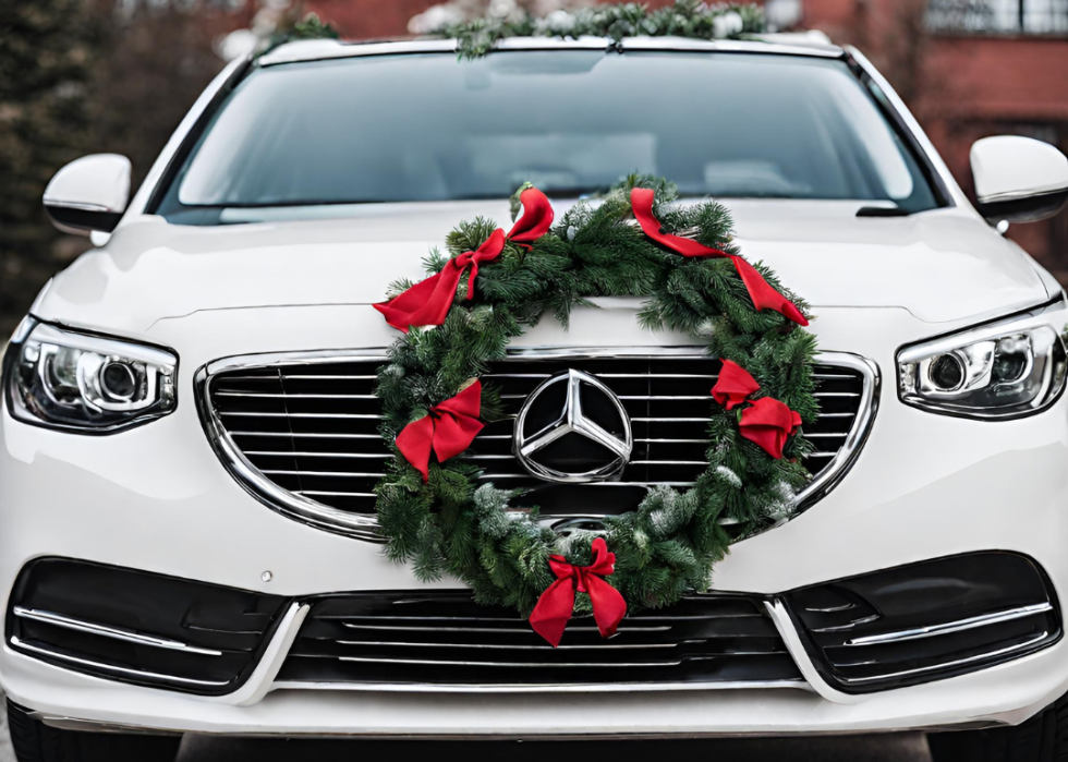 A Mercedes with a holiday wreath on the front grill