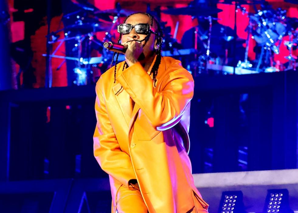 Rapper Tyra performing onstage in all-yellow outfit.