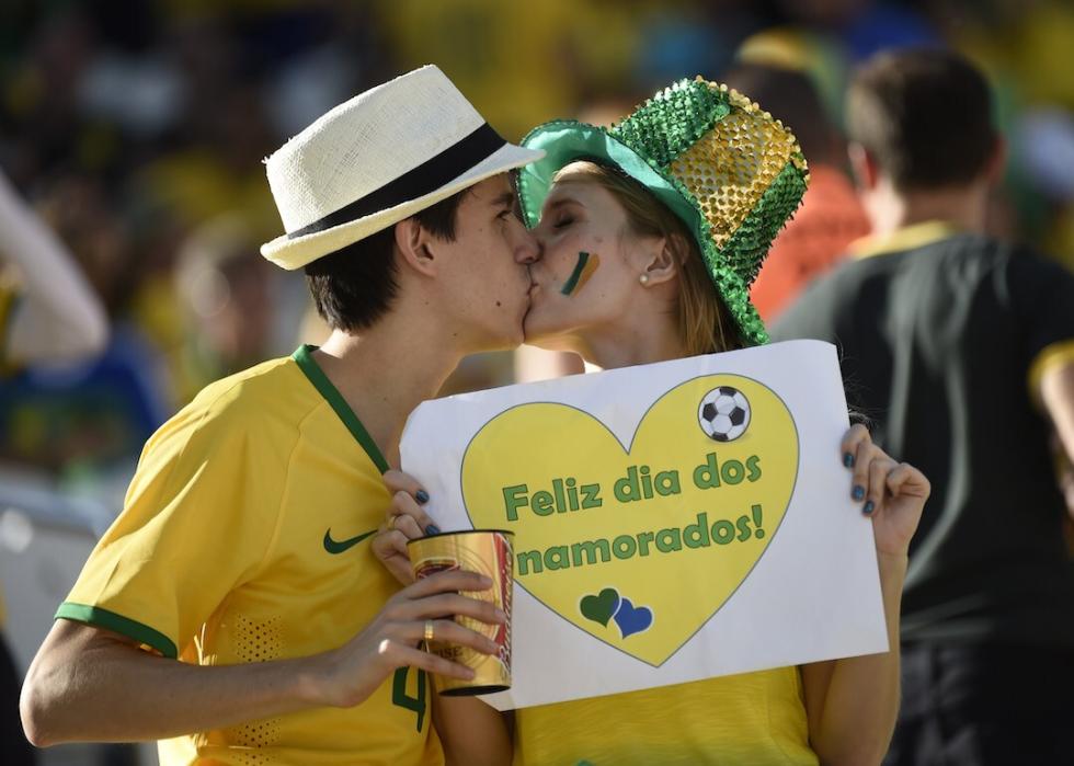Brazilian fans embrace and hold a sign reading in Portuguese, "Feliz dia dos namorados," before match between Brazil and Croatia at the Corinthians Arena in São Paulo on June 12, 2014.