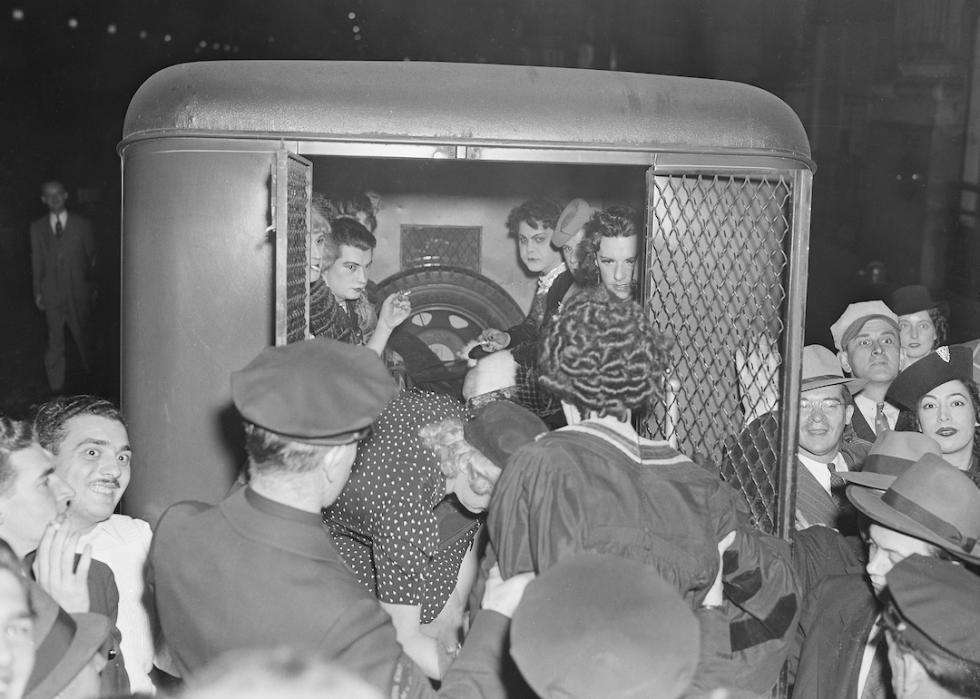 A group of revelers are shown being loaded into a 'paddy wagon' in 1939.