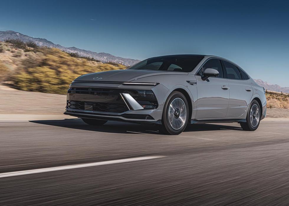 A silver metallic model of the Hyundai Sonata Hybrid in action on the road.