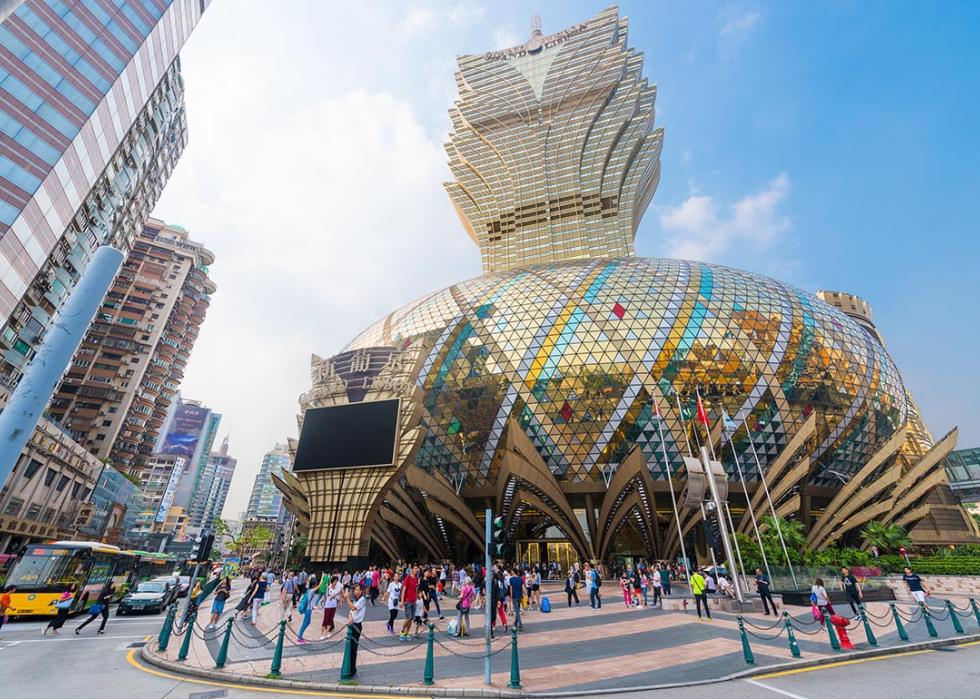 People stroll in front of the Grand Lisboa hotel, the tallest building in Macau.