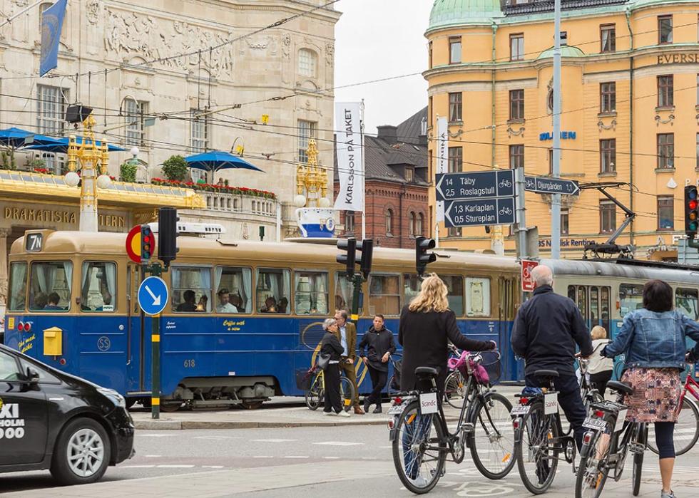 Traffic, bikes, and taxis cross traffic in a Swedish city center. 