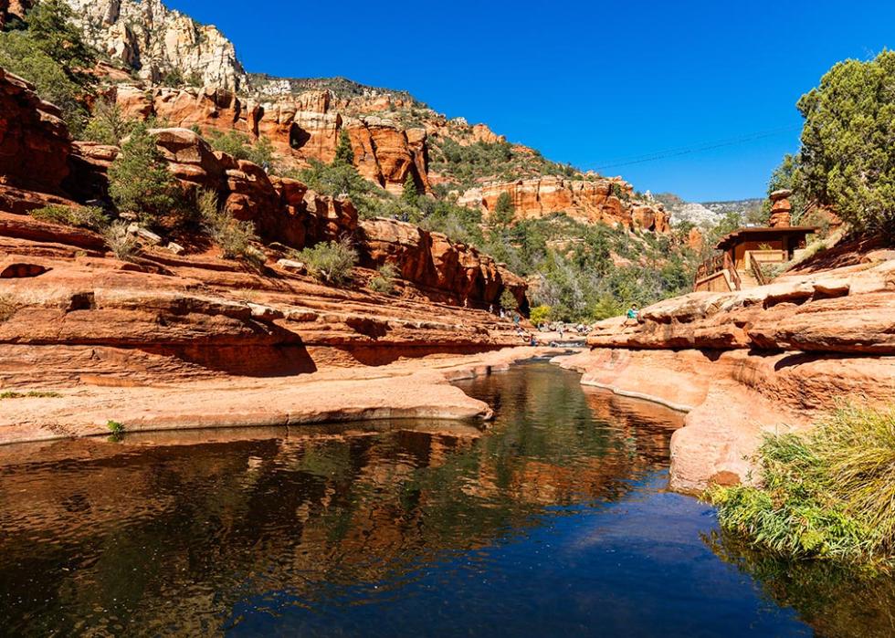 Visitors enjoying the beauty of Slide Rock State Park in October with its natural rock water slides in the Oak Creek Canyon near Sedona.