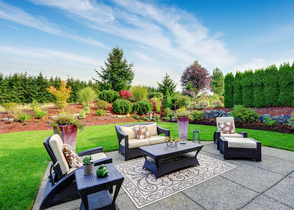 A vibrant well-maintained backyard with an outdoor furniture set.