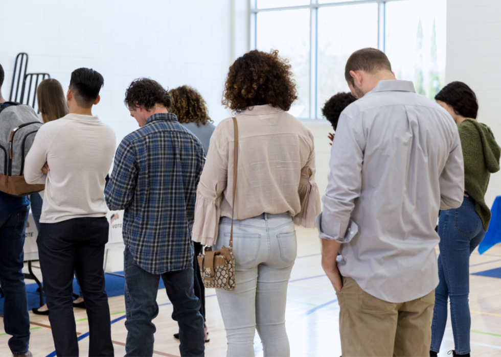 Two lines of people wait to sign up to vote.