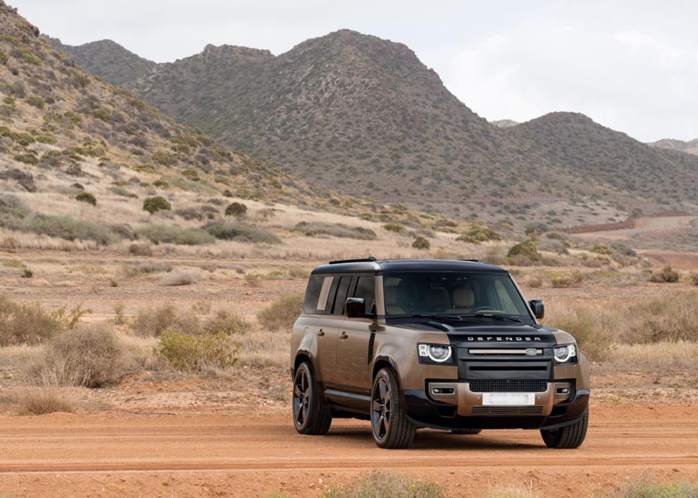 A brown 2025 Land Rover Defender on a desert road.