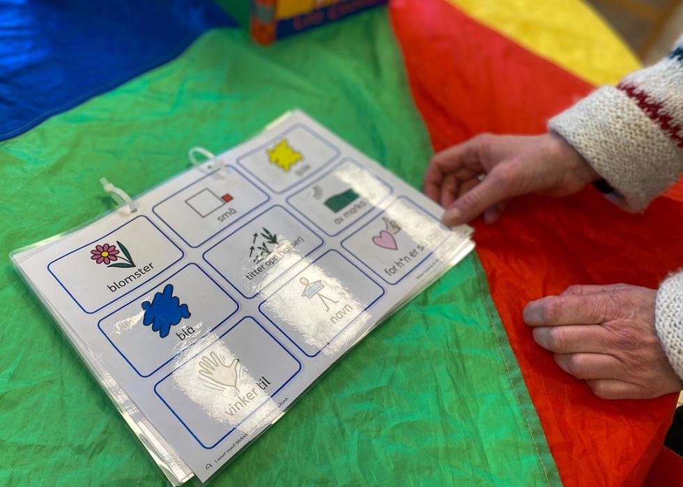 A teacher at a child care program run by Kanvas sets out a packet created to help children learning Norwegian communicate with staff members.